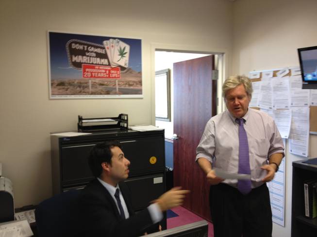 Sen. Tick Segerblom, D-Las Vegas, passes an aide in his office. In the background is a poster from "Fear and Loathing in Las Vegas."