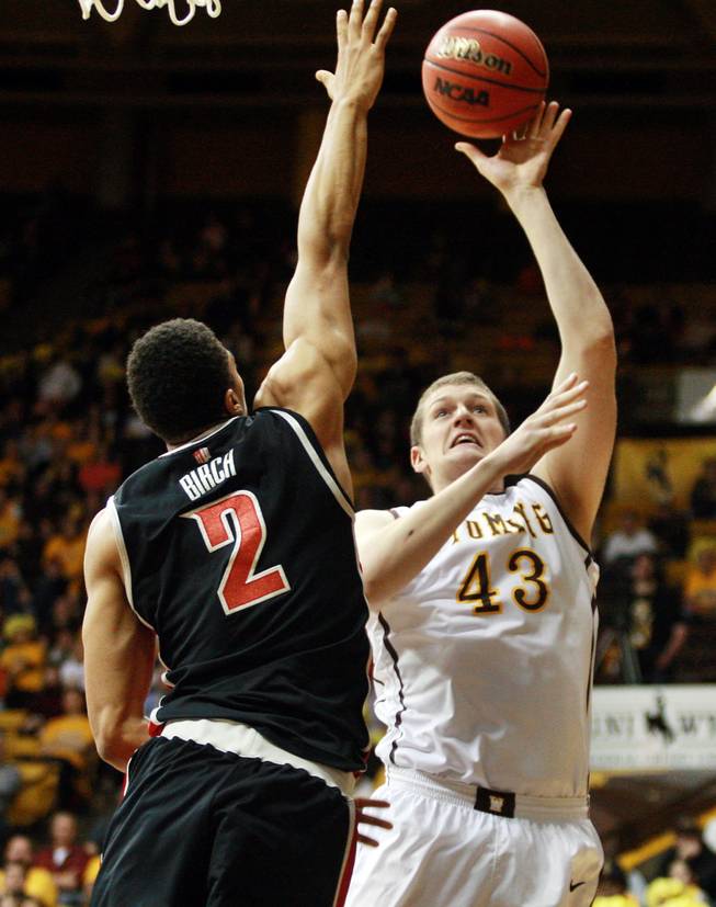 Wyoming's Matt Sellers tries to shoot over UNLV's Khem Birch during the first half of an NCAA college basketball game Saturday, Feb. 23, 2013, at the Arena-Auditorium in Laramie, Wyo. (AP Photo/Casper Star-Tribune, Alan Rogers)