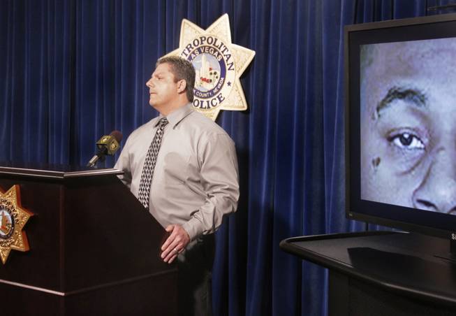 A screen shows shooting suspect Ammar Harris with a heart tattoo under his right eye while Las Vegas Metro Police Lt. Ray Steiber addresses the media with new information on the strip shooting, Monday, Feb. 25, 2013. 