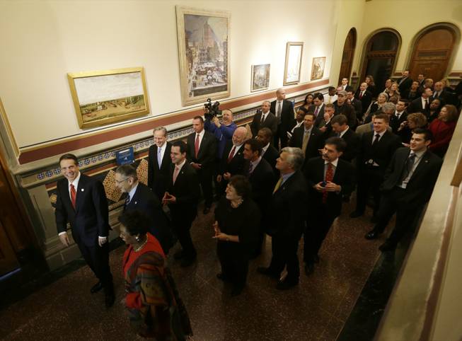 New York Gov. Andrew Cuomo, left, gives a tour of the Hall of New York to members of the legislature and media on Wednesday, Jan. 9, 2013, in Albany, N.Y. Paintings in the hallway depict scenes from around New York. Cuomo delivers his third State of the State address this afternoon. 