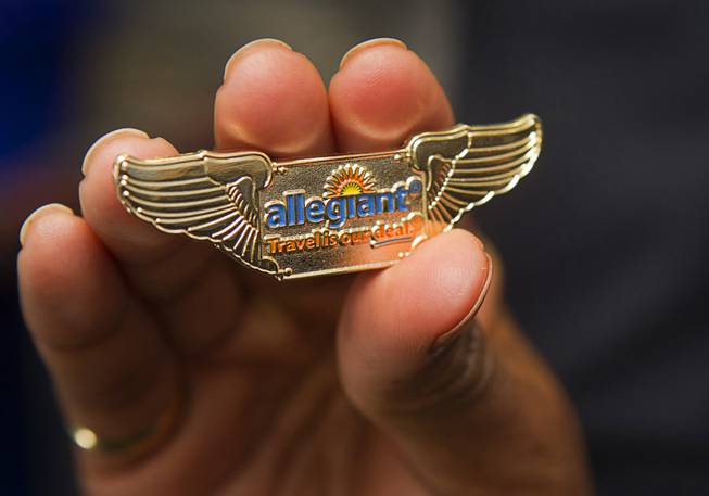 Allegiant Air flight attendant Felicia Fahey-Brown holds a wing pin as employees tour the company's new Airbus A319 passenger jet at McCarran International Airport Thursday, Feb. 28, 2013. The new jet is more fuel efficient than the company's current jets.