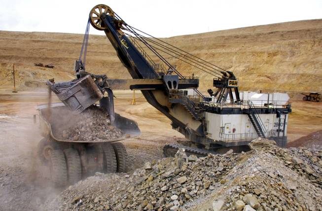 A cable shovel dumps gold ore into a truck in Crescent Valley in September 2001.