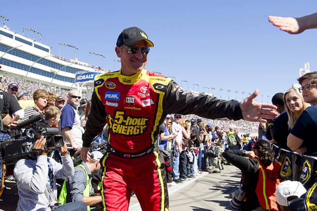 Driver Clint Bowyer (15) greets fans during driver introductions at the Kobalt Tools 400 NASCAR race at the Las Vegas Motor Speedway Sunday, March 10, 2013.