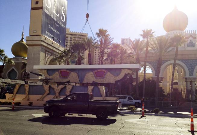 A piece of the Sahara sign is split in half during the dismantling of the casino sign, Tuesday, Mar. 12, 2013.