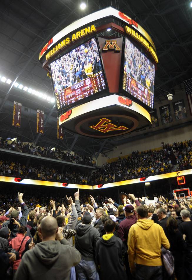 Fans fill the court after Minnesota defeated Indiana 77-73 in an NCAA college basketball game, Tuesday, Feb. 26, 2013, in Minneapolis. 