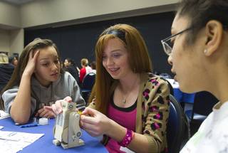 Alissa Lindquist, left, Breann McRae, center, and Ebony Medina work on a robot during the annual HerWorld workshop at the Henderson Convention Center Thursday, March 14, 2013. About 230 students attended the workshop, sponsored by DeVry University, intended to introduce female high school students to careers in science, technology, engineering and math.