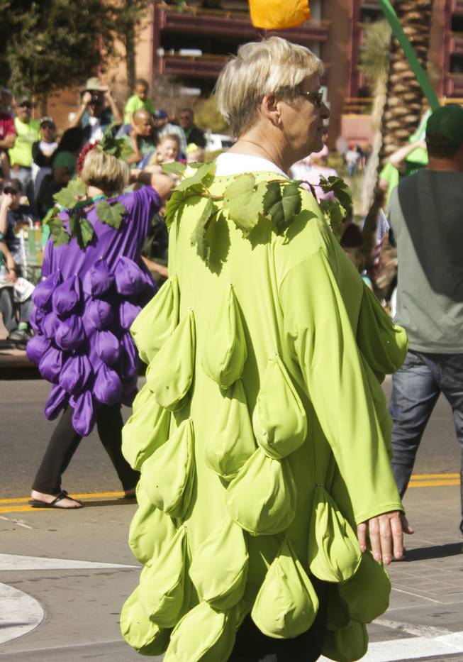 A member of the Grape Expectations Nevada School of Winemaking dressed in a grape costume passes by during the St. Patrick's Day Parade in downtown Henderson, Saturday, Mar. 16, 2013.