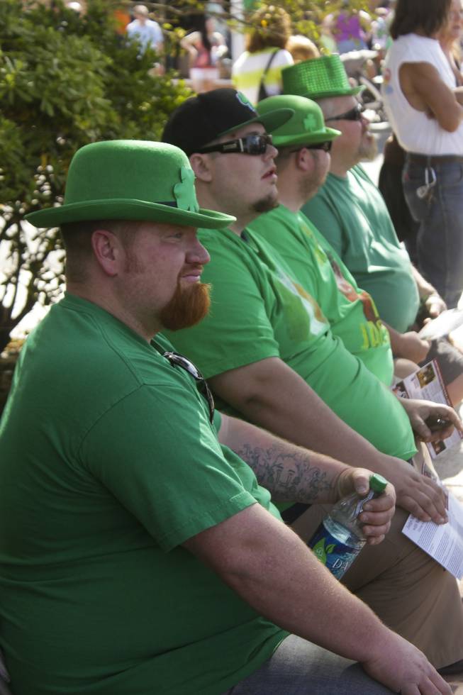 Four festive men in green watch the St. Patrick's Day Parade in downtown Henderson, Saturday, Mar. 16, 2013.