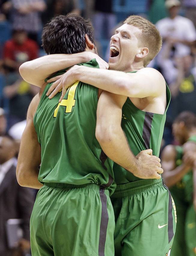 Oregon's E.J. Singler, right, and Arsalan Kazemi celebrate defeating UCLA 78-69 in the championship NCAA college basketball game in the Pac-12 Conference tournament, Saturday, March 16, 2013, in Las Vegas. (AP Photo/Julie Jacobson)