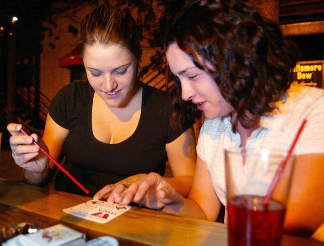 Sara Lively, 24, left and Michelle Coler, 21, test their drinks for date rape drugs at the Britannia Arms pub in San Jose, Calif., Sept. 19, 2002. Colleges around the country are buying millions of coasters that test for "date-rape" drugs in drinks. But law enforcement experts say the coasters are ineffective and could lead to more assaults by creating a false sense of security. The manufacturers — who also make fake snow and party foam — say the 40-cent paper coasters are 95 percent accurate. 