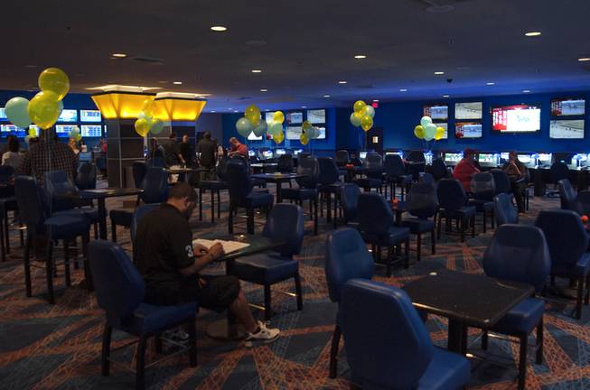 Balloons float above tables as various patrons mill about during the grand opening of the new William Hill Race & Sports Book inside the Plaza Hotel on Tuesday, Mar. 19, 2013.