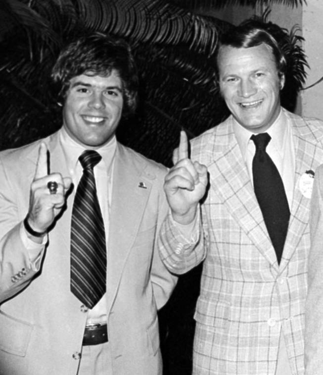 In this Jan. 2, 1976, file photo, University of Oklahoma football coach Barry Switzer, right, and quarterback Steven Davis, give the "number one" sign in Miami Beach, after the Associated Press named the Sooners as the national champions for the second year in a row.