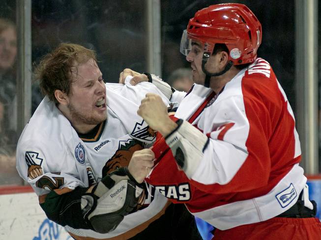 Adam Huxley, right, gets an open left to the face of Cody Carlson as the two players fought during the first period March 23, 2013, at the Orleans Arena.