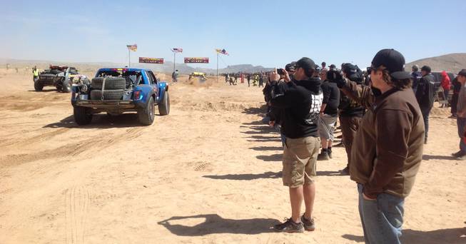Fans line the course of the Mint 400 off-road race Saturday, March 23, 2013, near Las Vegas.
