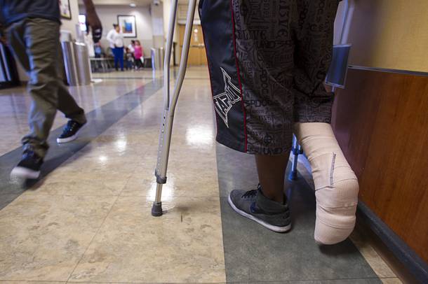 A patient stands in the emergency room lobby after being treated for a moped accident at Sunrise Hospital March 25, 2013. 