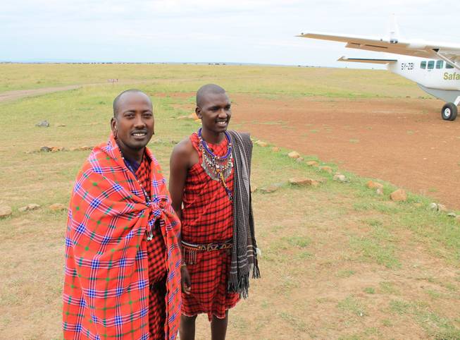 Porini Mara Camp employees Geoffrey Risa Ketere and Ripa Olmara greet a party of visitors at the Ol Kinyei Conservancy airfield. 