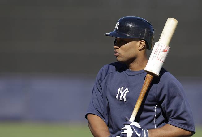 New York Yankees second baseman Robinson Cano warms up with a weight on his bat before a spring training baseball game in Tampa, Fla., March 21, 2013.