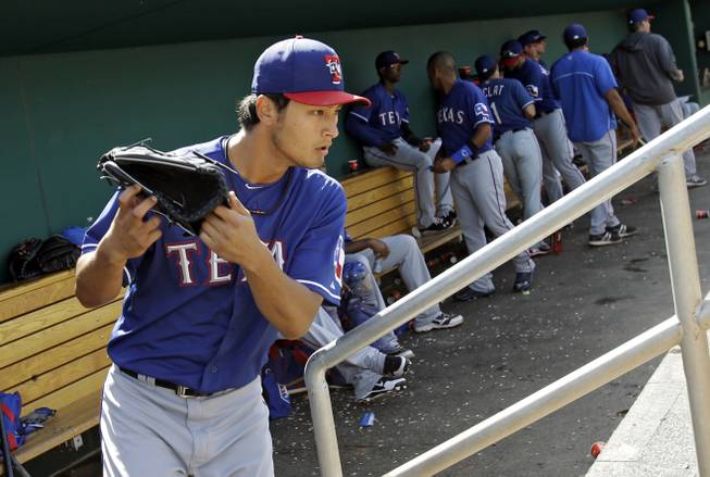 Texas Rangers starting pitcher Yu Darvish leaves the dugout to start the bottom of the fifth inning in an exhibition spring training baseball game against the Cincinnati Reds Saturday, March 23, 2013, in Goodyear, Ariz. 