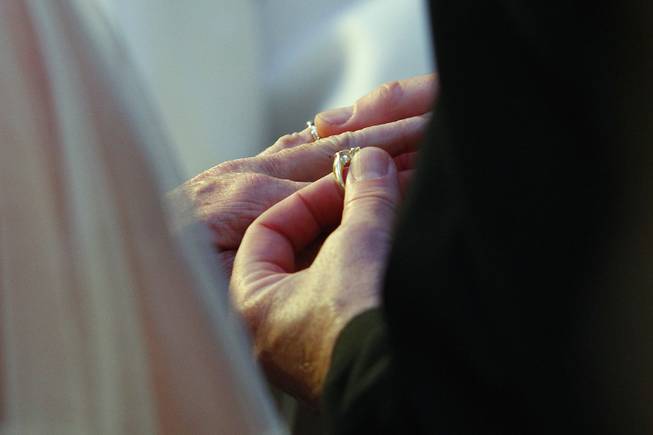 Steve Keller places a ring on Nancy Levandowski's finger as they exchange wedding vows at the Denny's restaurant on Fremont Street Wednesday, April 3, 2013.