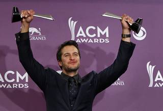 Luke Bryan holds his awards for Entertainer of the Year and Vocal Event of the Year at the 48th Annual Academy of Country Music Awards at MGM Grand on Sunday, April 7, 2013.