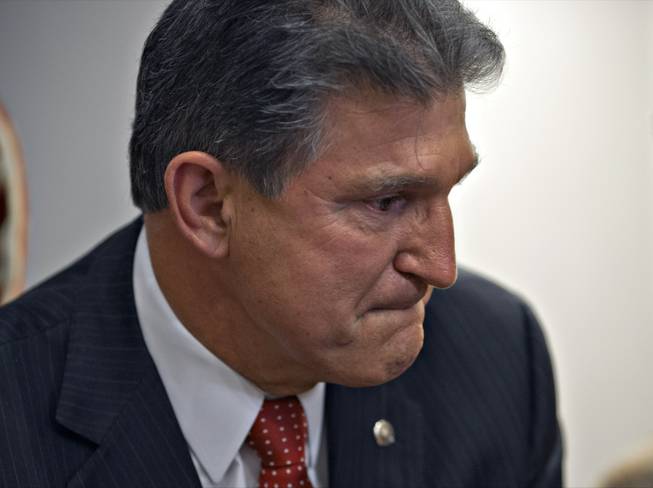 Sen. Joe Manchin, D-W.Va., becomes emotional as he meets in his office with families of victims of the Sandy Hook Elementary School shooting in Newtown, Conn., on the day he announced that they have reached a bipartisan deal on expanding background checks to more gun buyers, at the Capitol in Washington, Wednesday, April 10, 2013.