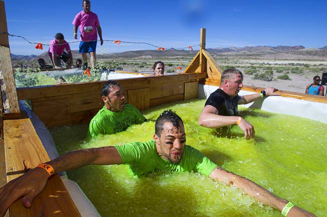 Competitors make their way through the "Arctic Enema" during the Tough Mudder in Beatty, Nev. Sunday, April 14, 2013. Tough Mudder events are hardcore 10-12 mile obstacle courses designed to test all-around strength, stamina, mental grit, and camaraderie.