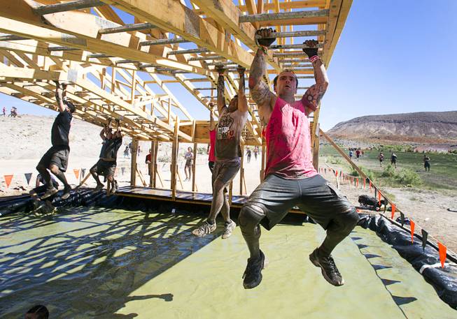 A man makes his way across the "Funky Monkey' during the Tough Mudder in Beatty, Nev. Sunday, April 14, 2013. Tough Mudder events are hardcore 10-12 mile obstacle courses designed to test all-around strength, stamina, mental grit, and camaraderie.
