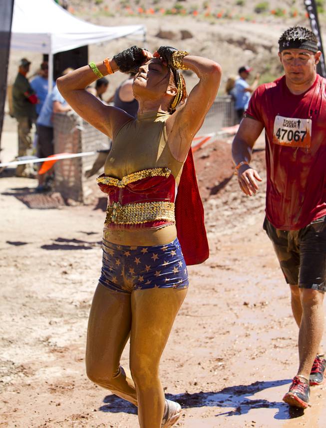Kali Jones of Las Vegas, dressed as Wonderwoman, crosses the finish line during the Tough Mudder in Beatty, Nev. Sunday, April 14, 2013. Tough Mudder events are hardcore 10-12 mile obstacle courses designed to test all-around strength, stamina, mental grit, and camaraderie.