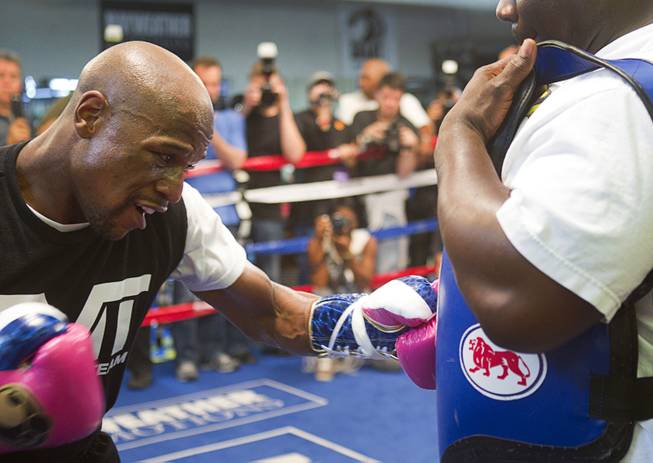 Undefeated welterweight boxer Floyd Mayweather Jr. hits a body pad worn by Nate Jones at the Mayweather Boxing Club Wednesday, April 17, 2013. Mayweather will defend his WBC welterweight title against Robert Guerrero at the MGM Grand Garden Arena on May 4.