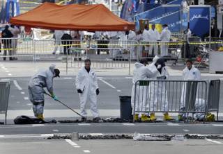 People in protective suits rake and examine material on Boylston Street in Boston Thursday, April 18, 2013 as investigation of the Boston Marathon bombings continues. 