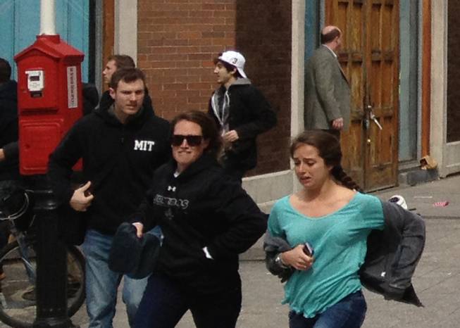This Monday, April 15, 2013, photo taken by David Green shows a man who was dubbed Suspect No. 2 in the Boston Marathon bombings by law enforcement, in the upper center of the frame, wearing a white baseball cap, walking away from the scene of the explosions. The FBI identified him as 19-year-old college student Dzhokhar Tsarnaev.