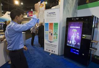 Steve Orlando of Phoenix plays a game on a vending machine equipped with XBox Kinect technology at a Pepsico booth during the NAMA (National Automatic Merchandising Association) One Show at the Sands Expo Center Wednesday, April 25, 2013. The NAMA One Show convention serves the vending, coffee and food service industries.