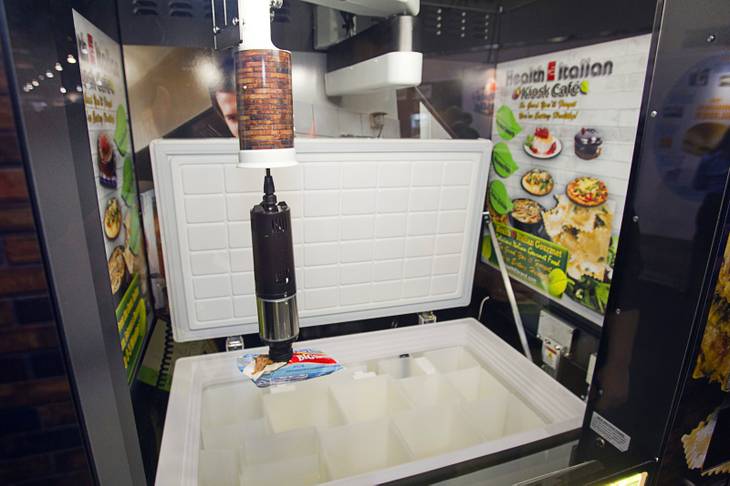 A mechanical vacuum arm picks an ice cream sandwich from a freezer box at the Fastcorp booth during the NAMA (National Automatic Merchandising Association) One Show at the Sands Expo Center Wednesday, April 25, 2013. The NAMA One Show convention serves the vending, coffee and food service industries.