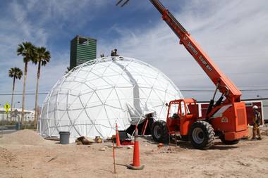 Workers install a fabric sheet on a geodesic dome that will become part of the Downtown Container Park near Seventh and Fremont streets.