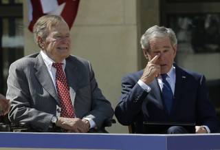 Former president George W. Bush wipes a tear after his speech during the dedication of the George W. Bush Presidential Center Thursday, April 25, 2013, in Dallas. Former president George H.W. Bush is at left. 