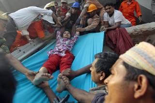 Rescuers lower down a survivor from the debris of a building that collapsed in Savar, near Dhaka, Bangladesh, Wednesday, April 24, 2013. An eight-storey building housing several garment factories collapsed near Bangladeshs capital on Wednesday, killing dozens of people and trapping many more under a jumbled mess of concrete. Rescuers tried to cut through the debris with earthmovers, drilling machines and their bare hands.