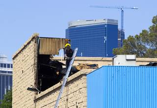 A firefighter prepares to descend a ladder after a fire at a medical building at Maryland Parkway near Vegas Valley Drive Wednesday,  May 1, 2013.