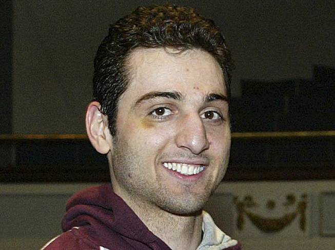 In this Feb. 17, 2010, photo, Tamerlan Tsarnaev, left, smiles after accepting the trophy for winning the 2010 New England Golden Gloves Championship in Lowell, Mass. Relatives of Tsarnaev, the older of the brothers suspected in the Boston Marathon bombing, will claim his body now that his wife has agreed to release it, an uncle said as officials in the U.S. and Russia deepened their investigations into him.