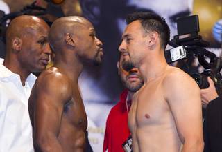 Undefeated WBC welterweight champion Floyd Mayweather Jr., left, and Robert Guerrero face off during an official weigh-in at the MGM Grand Garden Arena Friday, May 3, 2013. Mayweather will defend his title against Guerrero at the arena on Saturday. Bernard Hopkins, IBF light heavyweight champion looks on at far left.