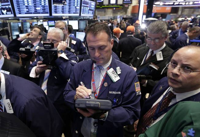 In this Thursday, May 2, 2013, photo, traders gather at a post on the floor of the New York Stock Exchange. Stock markets edged higher on Friday May 3, 2013, ahead of the release of the U.S. government's monthly unemployment report, a key measure of the health of the world's largest economy.