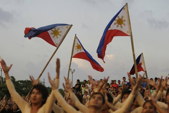 Filipinos watch as dancers use Philippine flags as part of their performance during the 113th Philippine Independence Day celebrations at  Manila's Rizal Park, Philippines on Sunday June 12, 2011. Philippine independence from Spain was proclaimed on June 12, 1898.