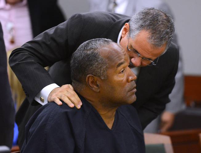 O.J. Simpson and his defense attorney Ozzie Fumo confer during an evidentiary hearing for Simpson in Clark County District Court on May 17, 2013, in Las Vegas.