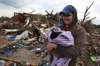 Austin Brock holds cat Tutti, shortly after the animal was retrieved from the rubble of Brock's home, which was demolished a day earlier when a tornado moved through Moore, Okla., Tuesday, May 21, 2013. A huge tornado roared through the Oklahoma City suburb Monday, flattening an entire neighborhoods and destroying an elementary school with a direct blow as children and teachers huddled against winds. 