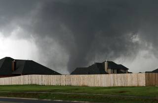A tornado moves past homes in Moore, Okla. on Monday, May 20, 2013.