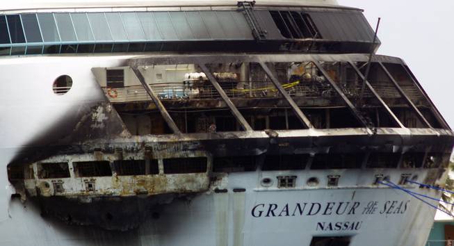 The fire-damaged exterior of Royal Caribbean's Grandeur of the Seas cruise ship is seen while docked in Freeport, Grand Bahama island, Monday, May 27, 2013. Royal Caribbean said the fire occurred early Monday while on route from Baltimore to the Bahamas on the mooring area of deck 3 and was quickly extinguished. All 2,224 guests and 796 crew were safe and accounted for.