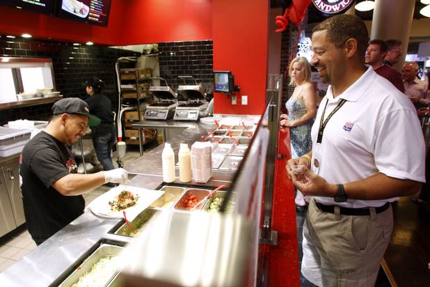 Lalo Gomez makes up a burrito for Fred Williamson Jr. during the grand opening of Chronic Tacos at the Palms Friday, May 31, 2013.