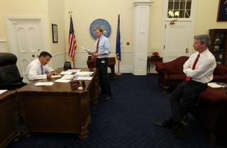 Nevada Gov. Brian Sandoval signs bills in his office at the Capitol with intergovernmental affairs manager Tyler Klimas, center, and Chief of Staff Gerald Gardner during the final hours of the 77th legislative session in Carson City, Monday, June 3, 2013. 