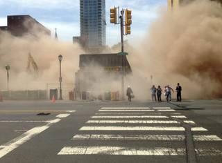 In this photo provided by Jordan McLaughlin, a dust cloud rises as people run from the scene of a building collapse on the edge of downtown Philadelphia on Wednesday, June 5, 2013. A building that was being torn down collapsed with a thunderous boom, raining bricks on a neighboring thrift store, killing a woman and injuring at least 13 other people in an accident that witnesses said was bound to happen.