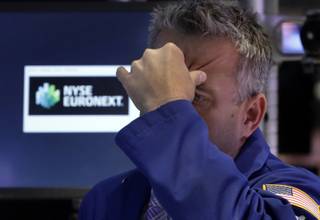 Specialist Christopher Culhane squeezes his forehead as he works on the floor of the New York Stock Exchange, Thursday, June 20, 2013. There was no let-up in the flight from stocks and bonds Thursday, and the Dow Jones industrial average fell more than 300 points. 