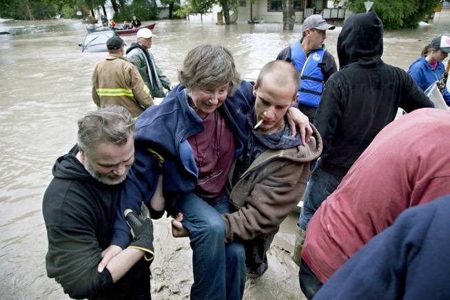 A woman is rescued from the flood waters in High River, Alberta on Thursday, June 20, 2013 after the Highwood River overflowed its banks. 